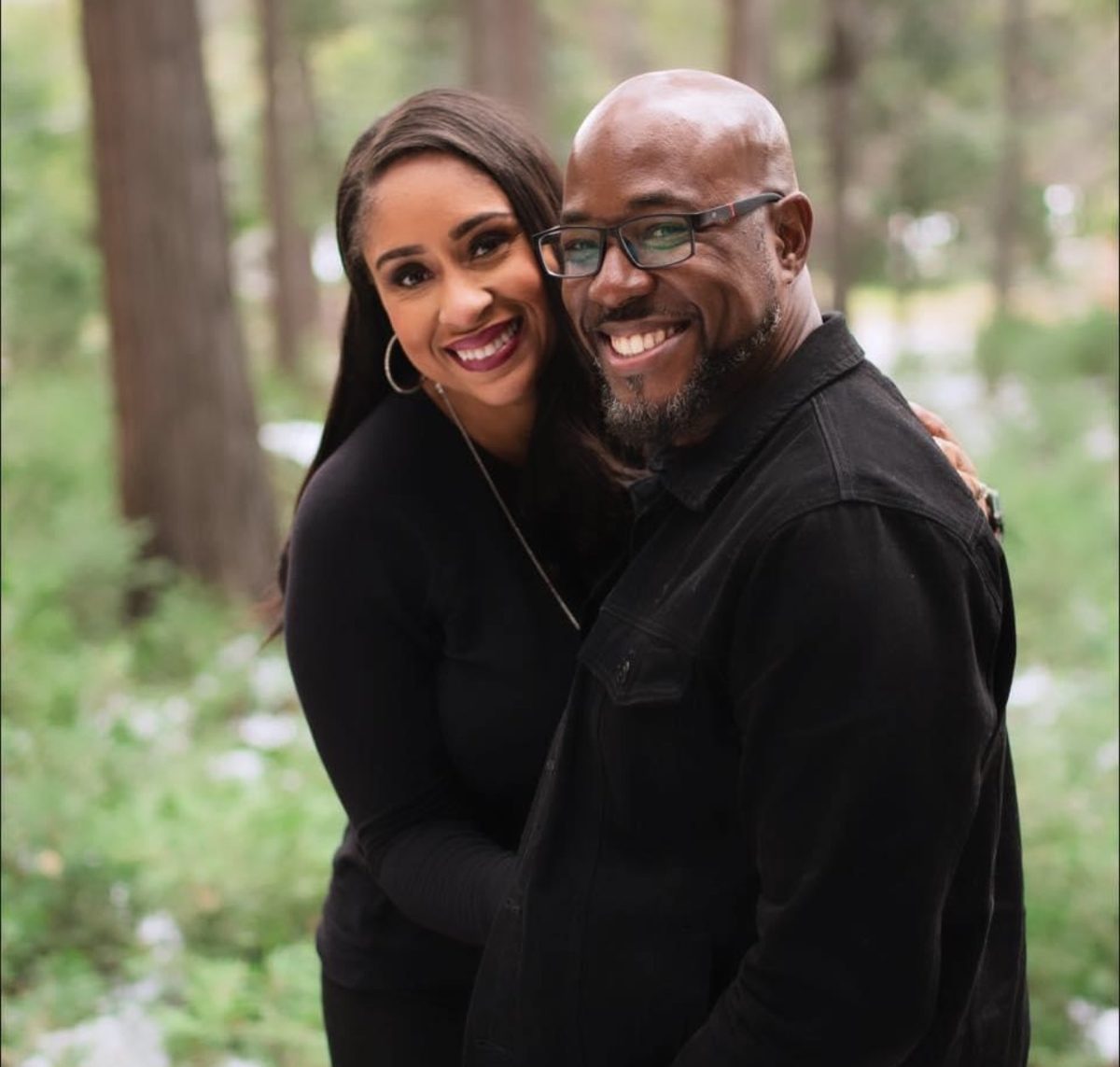 Devo and Donna, Joyco's founders, smiling together outdoors among trees